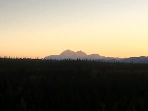Eine Landschaft mit einem Gebirge im Hintergrund und einer ebenen Fläche im Vordergrund.