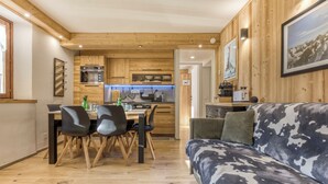 Ein gemütliches Blockhaus-Interieur mit Essbereich, Holzwänden und einer Couch.