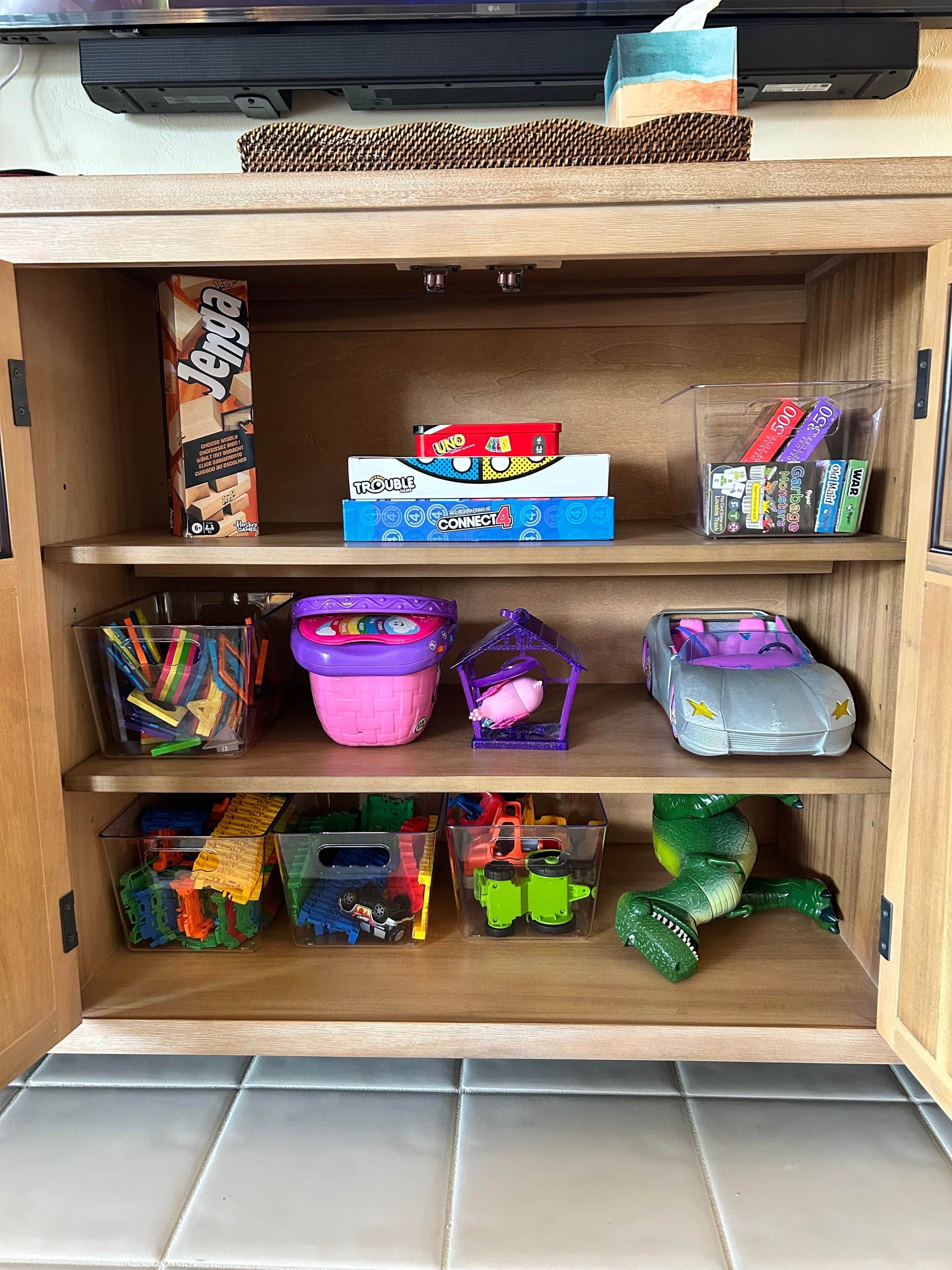 A storage area with shelves containing various items including board games, toys, and storage bins.