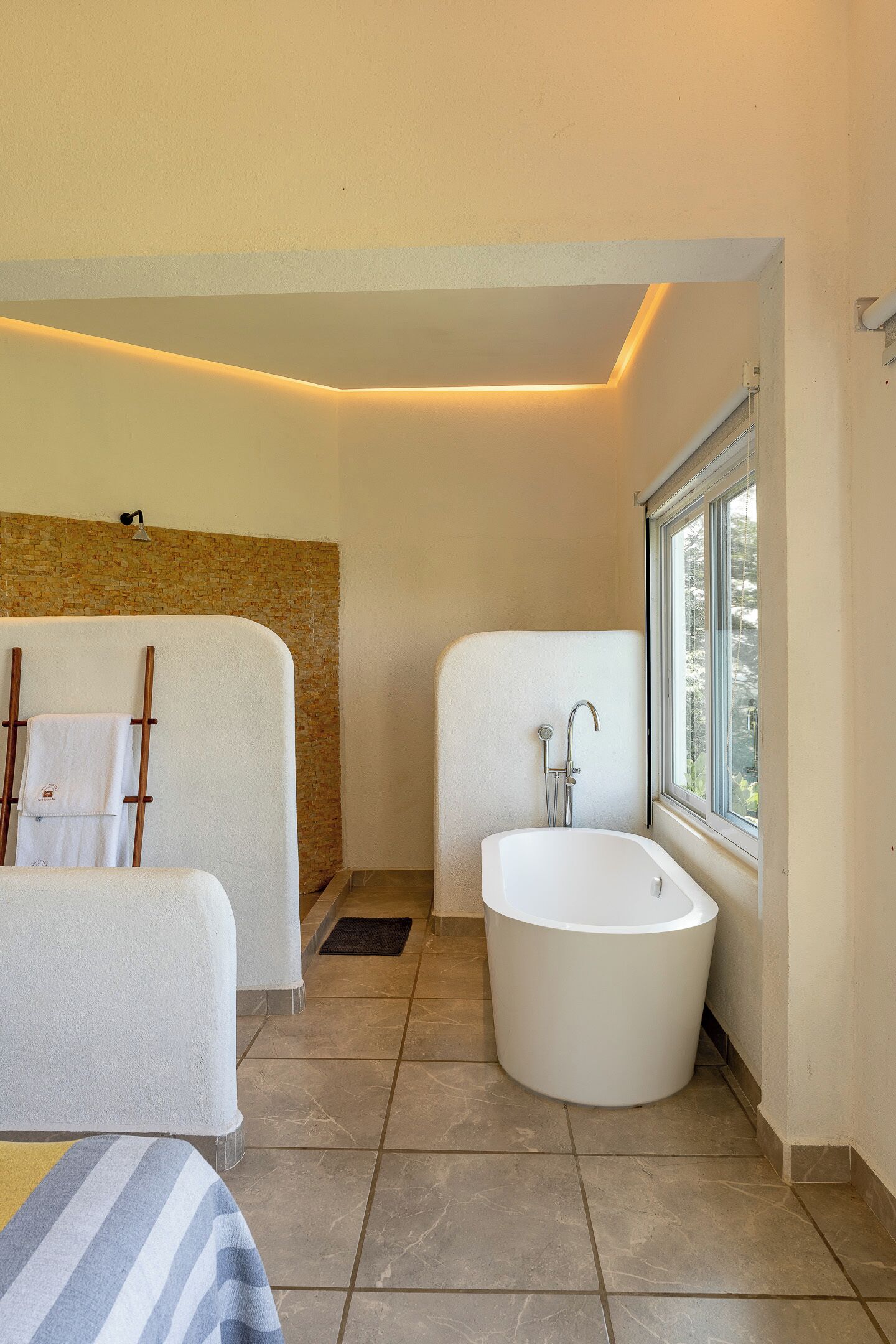 A bathroom with a bathtub, a shower, and a towel rack.