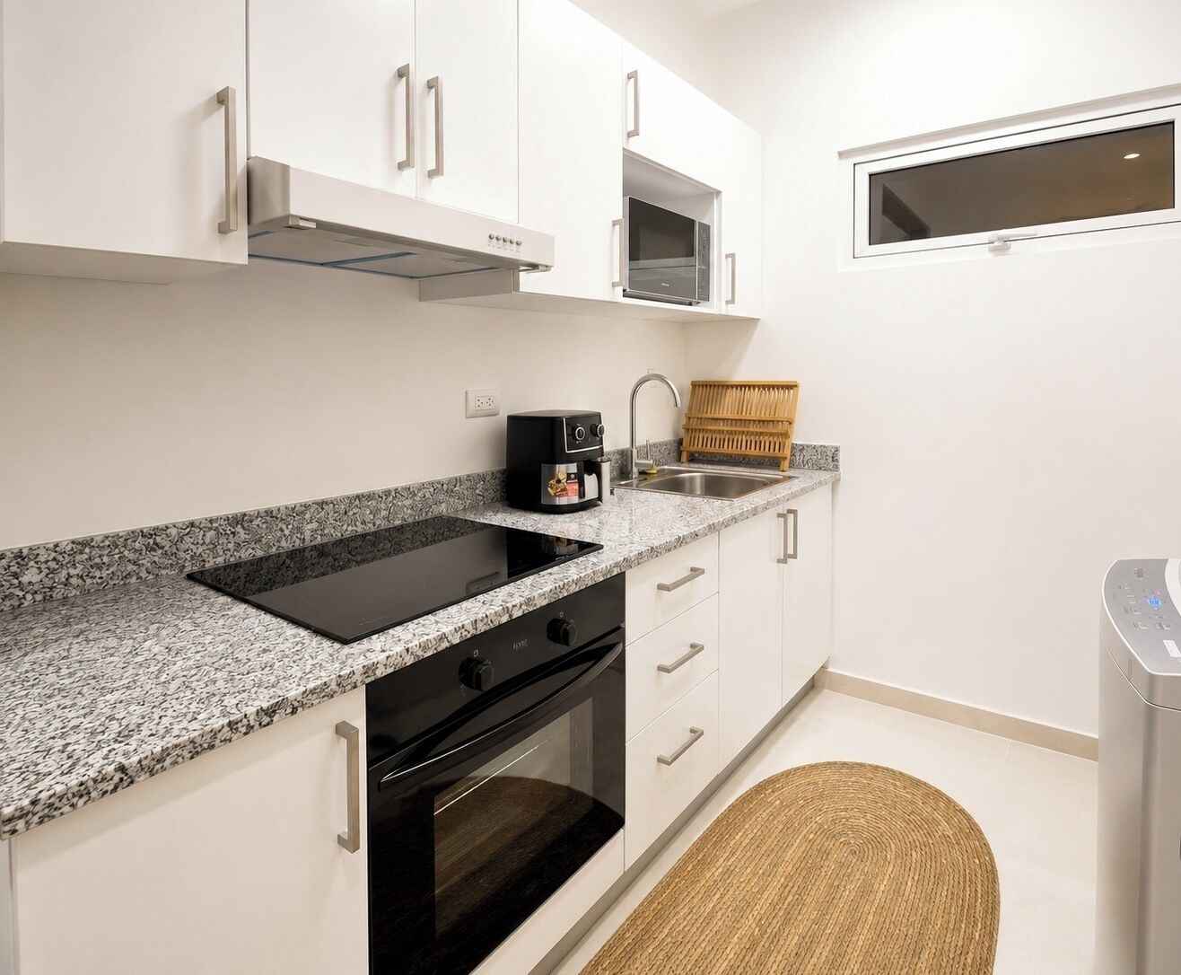 A modern kitchen with a built-in stove, microwave, and oven.