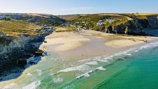 A coastal town with a sandy beach, rocky cliffs, and houses along the coastline. - Kippy Cottage (Truro)