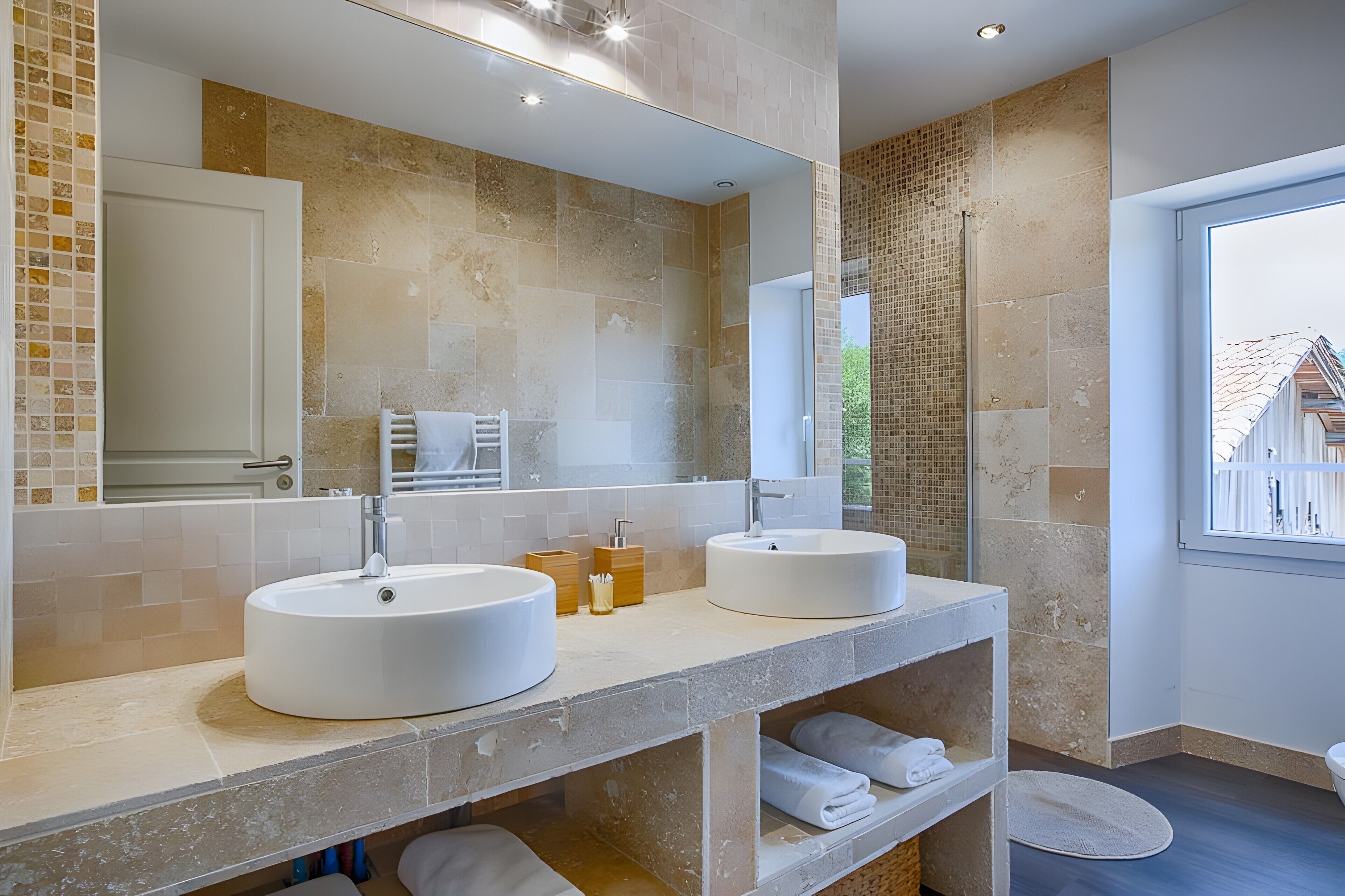Un baño moderno con dos lavamanos, un espejo grande y vistas al exterior.