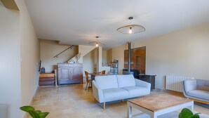 Ein modernes Wohnzimmer mit einem weißen Sofa, einem Couchtisch und einem Essbereich mit einem Stuhl und Tisch.
