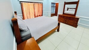 A bedroom with a bed, dresser, mirror, and curtains. - Beachfront House in El Tamarindo (El Tamarindo)