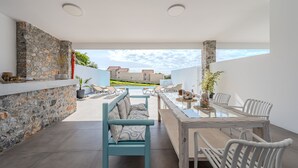 Eine Terrasse im Freien mit Steinmauern, einem Holztisch und Stühlen.