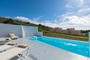A rooftop pool with lounge chairs and a clear view of the surrounding landscape. - Mythos 9 Villa (Agios Vasileios)