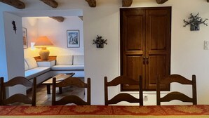 Una habitación con puerta de madera, un sofá, una mesa y una lámpara.