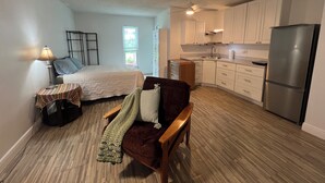 A compact living space with a bed, a small table, a chair, a kitchenette, and a window. - Cozy studio in Port St. Lucie with AC -WiFi for relaxing stays (Port St. Lucie)