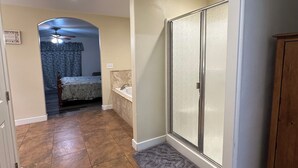 Un baño con ducha, bañera y tocador.