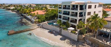 A coastal hotel with a pool, beach access, and a view of the ocean.
