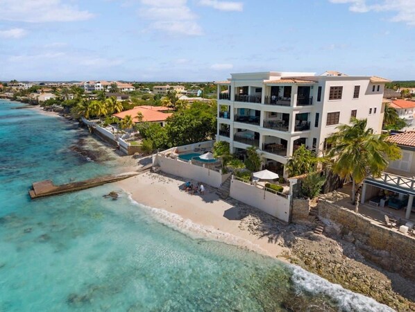 Un hôtel situé sur la côte, doté d’une piscine, d’un accès à la plage et offrant une vue sur l’océan.