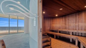 Een sauna met houten banken en uitzicht op het strand.