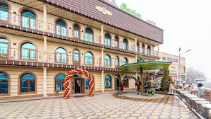 Un grand bâtiment historique doté de nombreux balcons et de fenêtres en arc de cercle, sur lequel on peut voir une enseigne bien visible indiquant « Jardin PIM ».