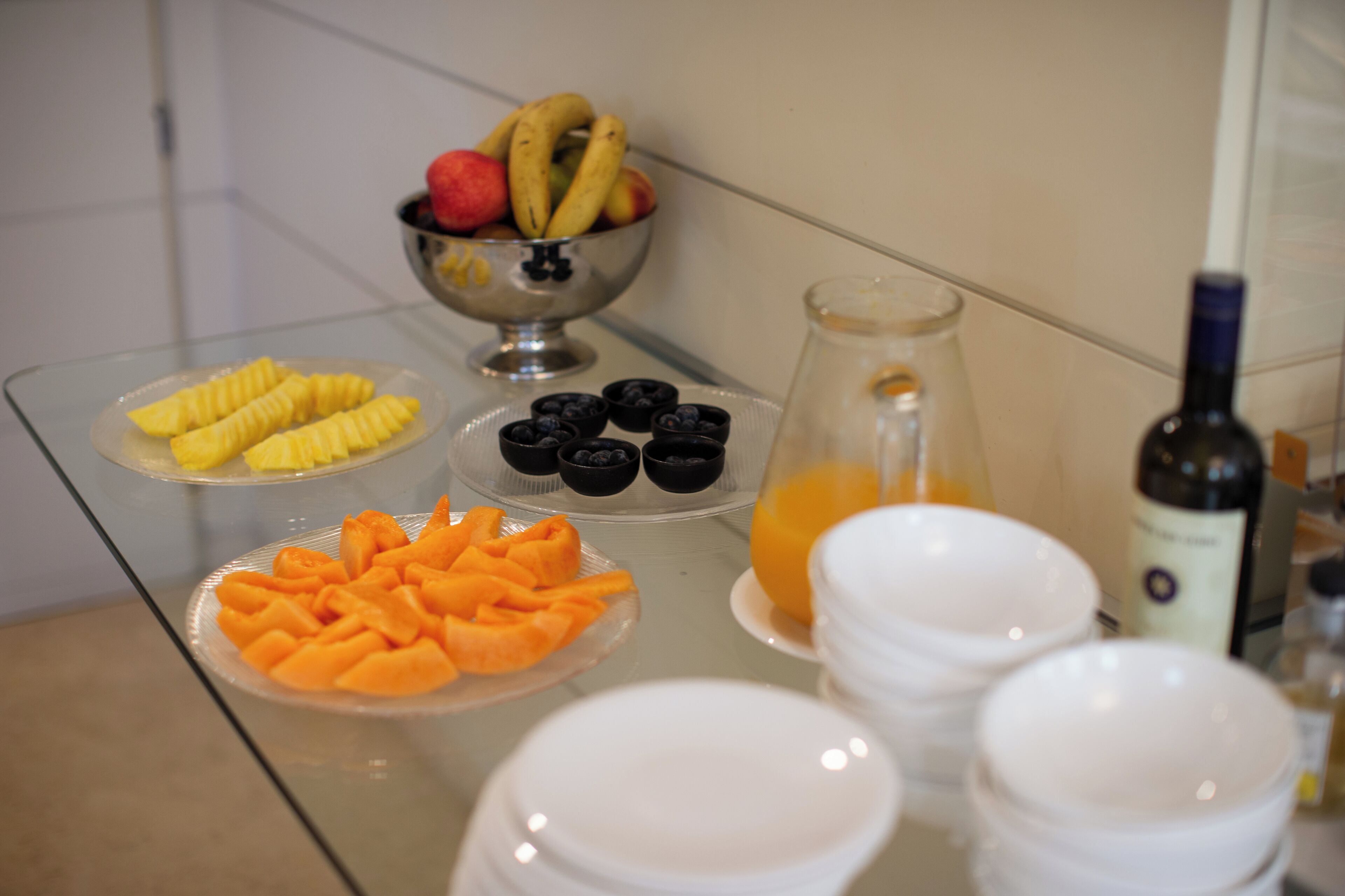 Um buffet de café da manhã com diversas frutas e bebidas.