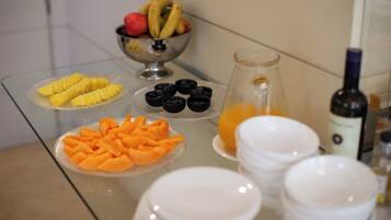 Um buffet de café da manhã com diversas frutas e bebidas.