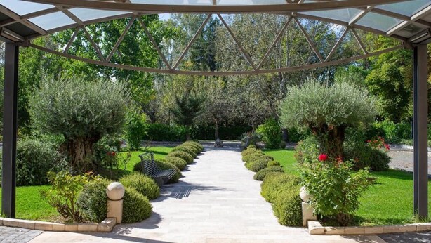 A covered garden pathway with a symmetrical design, surrounded by neatly trimmed hedges and trees. - Hotel La Dimora del Baco (L'Aquila)