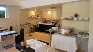 A modern dining area with glass tables, chairs, and a buffet setup. - Hotel La Dimora del Baco (L'Aquila)