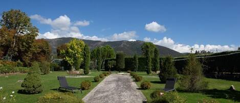 A pathway leading to a seating area with a view of mountains.