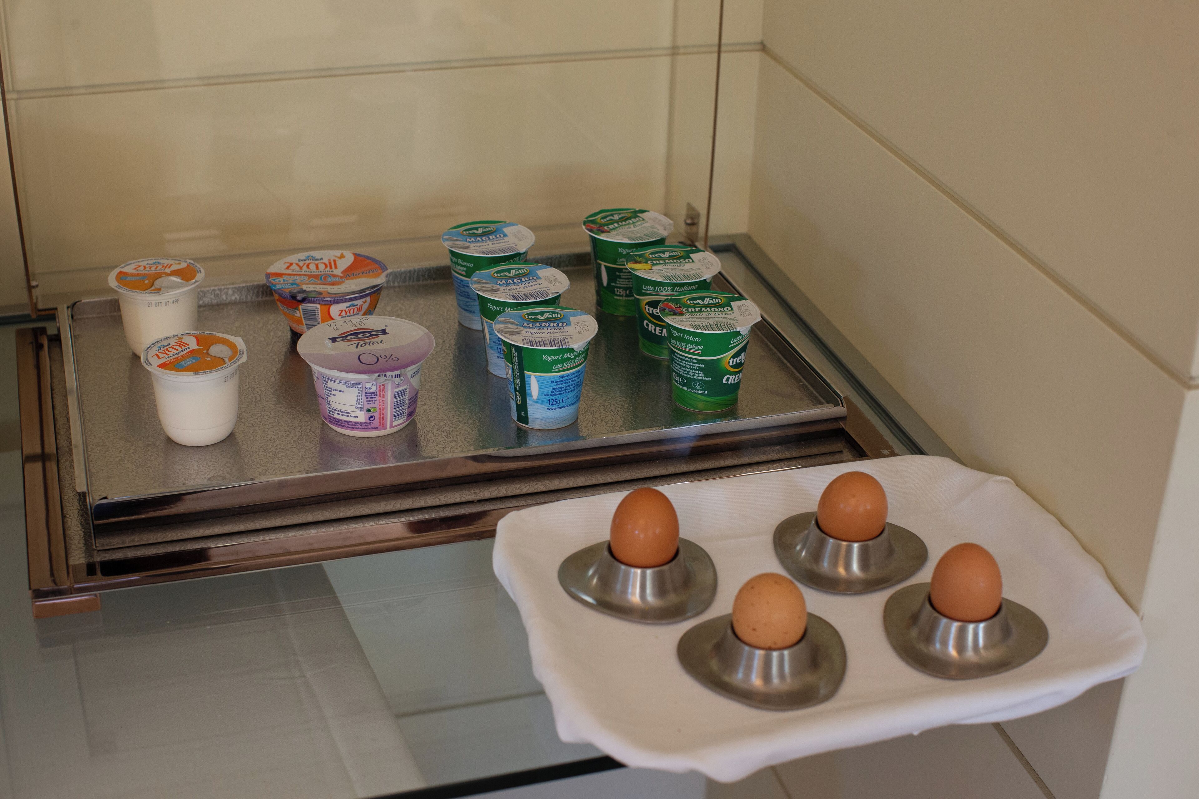 Una estantería de refrigerador con diversos productos lácteos y huevos.