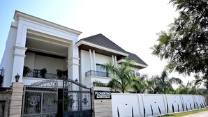 A two-story house with a gated entrance, a balcony, and a sign reading 'FLORENTINO The Luxury Villa.' - Florentino The Luxury Villa (Amritsar)