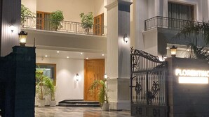A modern two-story building with a gated entrance, a balcony, and a well-lit interior. - Florentino The Luxury Villa (Amritsar)