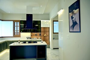 Una cocina moderna con una isla central, armarios empotrados y un amplio ventanal.