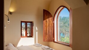 A bedroom with a bed, a window with wooden shutters, and a wall-mounted light fixture. - Beit El Mona Sanctuary (Sea & Beach Front) (Hurghada)