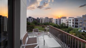 Ein Balkon mit Blick auf ein Wohngebiet und einen Sonnenuntergang.