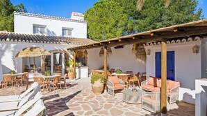 A patio area with outdoor seating, a thatched umbrella, and a stone floor. - House - Sleeps 10 to 34 - Heated Pool - Parking (Javea)