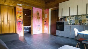 A modern interior with a sofa, a kitchen with a stove, and a dining area. - Secret Garden (Grottolella)