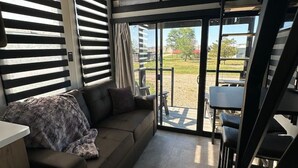 Un intérieur moderne comprenant un canapé, un coin repas et un escalier.