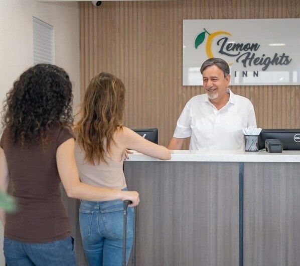 Uma mesa de recepção no Lemon Heights Inn com um letreiro acima.