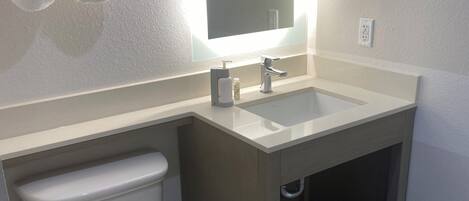A modern bathroom with a toilet, sink, and towel rack.