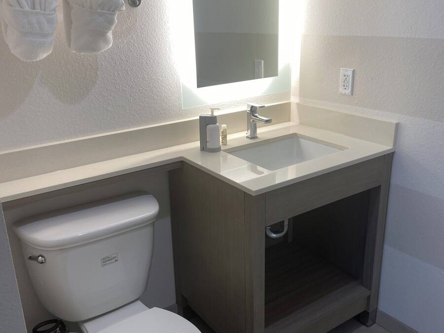 Ein modernes Badezimmer mit Toilette, Waschbecken und Handtuchhalter.