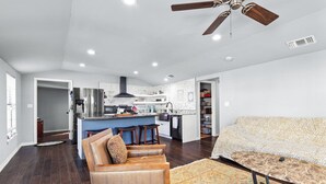 A modern living room with a sofa, a coffee table, and a patterned rug. - Spacious 4-bedroom house in welcoming San Antonio near trails, Pearl, Gardens (San Antonio)