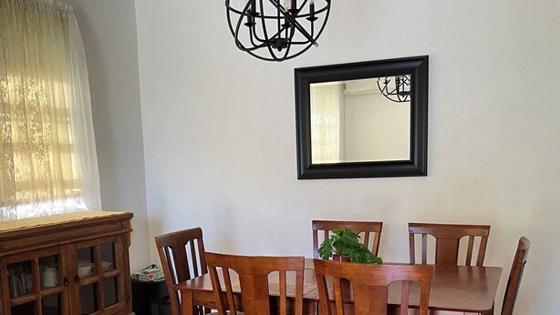 A dining area with a wooden table and chairs, a cabinet, a mirror, and a potted plant. - Loma Bella/ Private Villa for 14 near beach,2 homes  (Patillas)