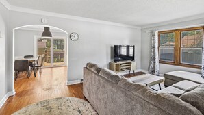 A living room with a sofa, TV, and dining area. - Beautiful 3-bedroom house with AC in adorable Des Moines (Des Moines)