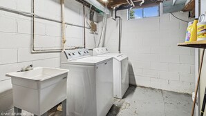 A laundry room with a washing machine, dryer, and sink. - Beautiful 3-bedroom house with AC in adorable Des Moines (Des Moines)