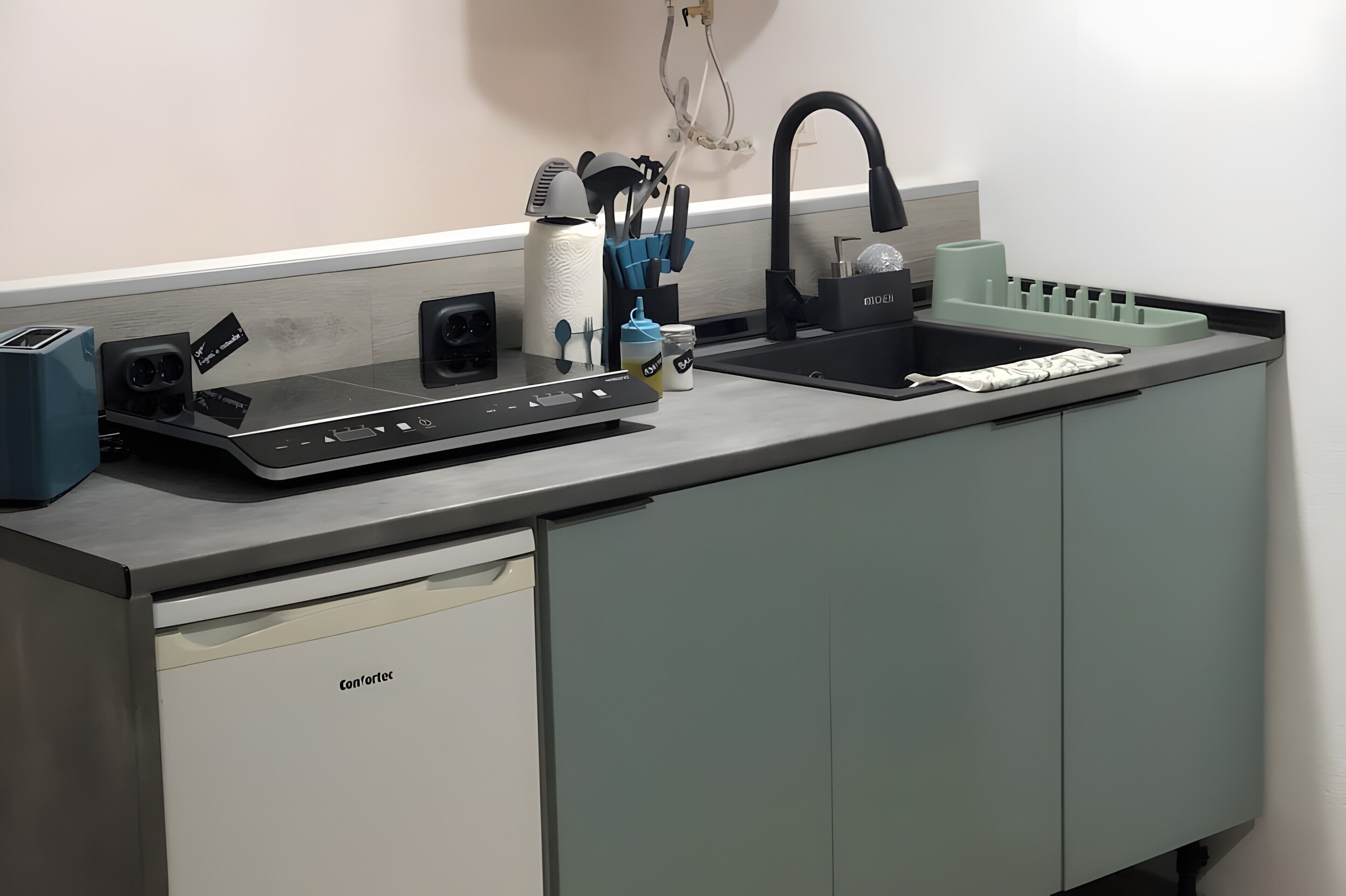 A kitchen with a built-in dishwasher, a sink with a faucet, and a countertop with various utensils and appliances.