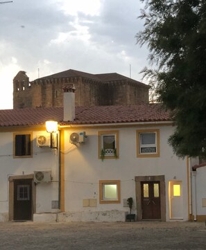 A building with a tiled roof, a chimney, and a street lamp.