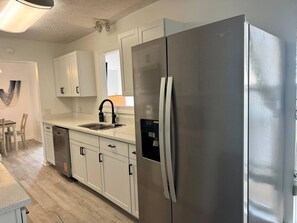 Fully-equipped modern kitchen with stainless steel appliances. Perfect for cooking meals and just steps from the dining area. - Beach Ya To It! Private Pool, Hot Tub, + Game Room! (Panama City Beach)