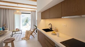 A modern kitchen with wooden cabinets, a black sink, and a dining area with a table and chairs.