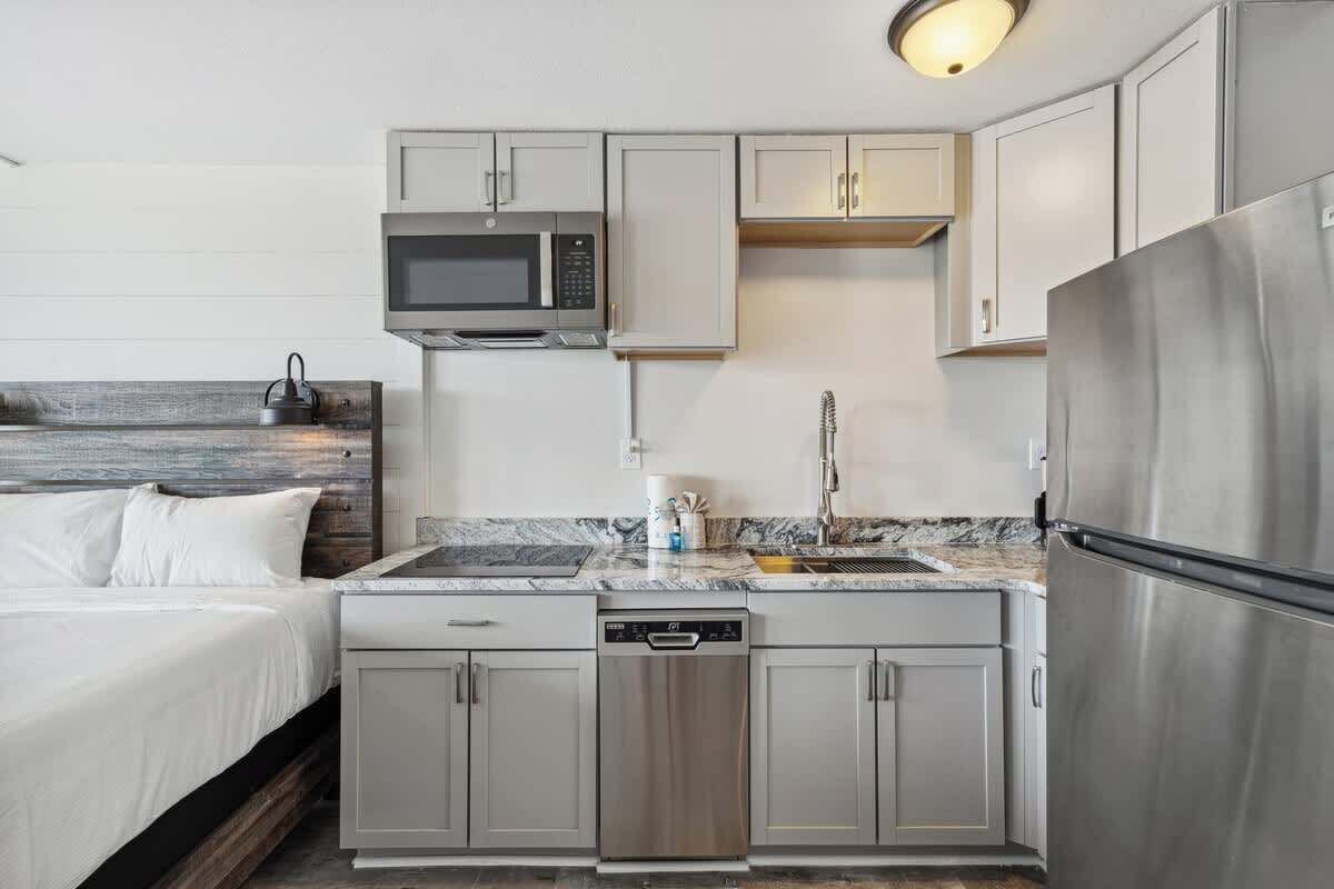 A compact kitchen with a microwave, dishwasher, and refrigerator.