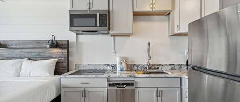 A compact kitchen with a microwave, dishwasher, and refrigerator.