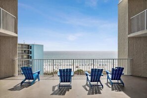 A balcony with three blue chairs facing a beach. - Top Of The Gulf 704 - Beautiful Studio (Panama City Beach)