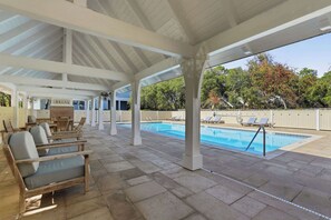 A covered pool area with lounge chairs, a brick wall, and a sign that reads "RELAX". - Family Coastal Escape (Inlet Beach)