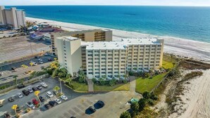 Un hotel su più piani con parcheggio e vista sulla spiaggia.
