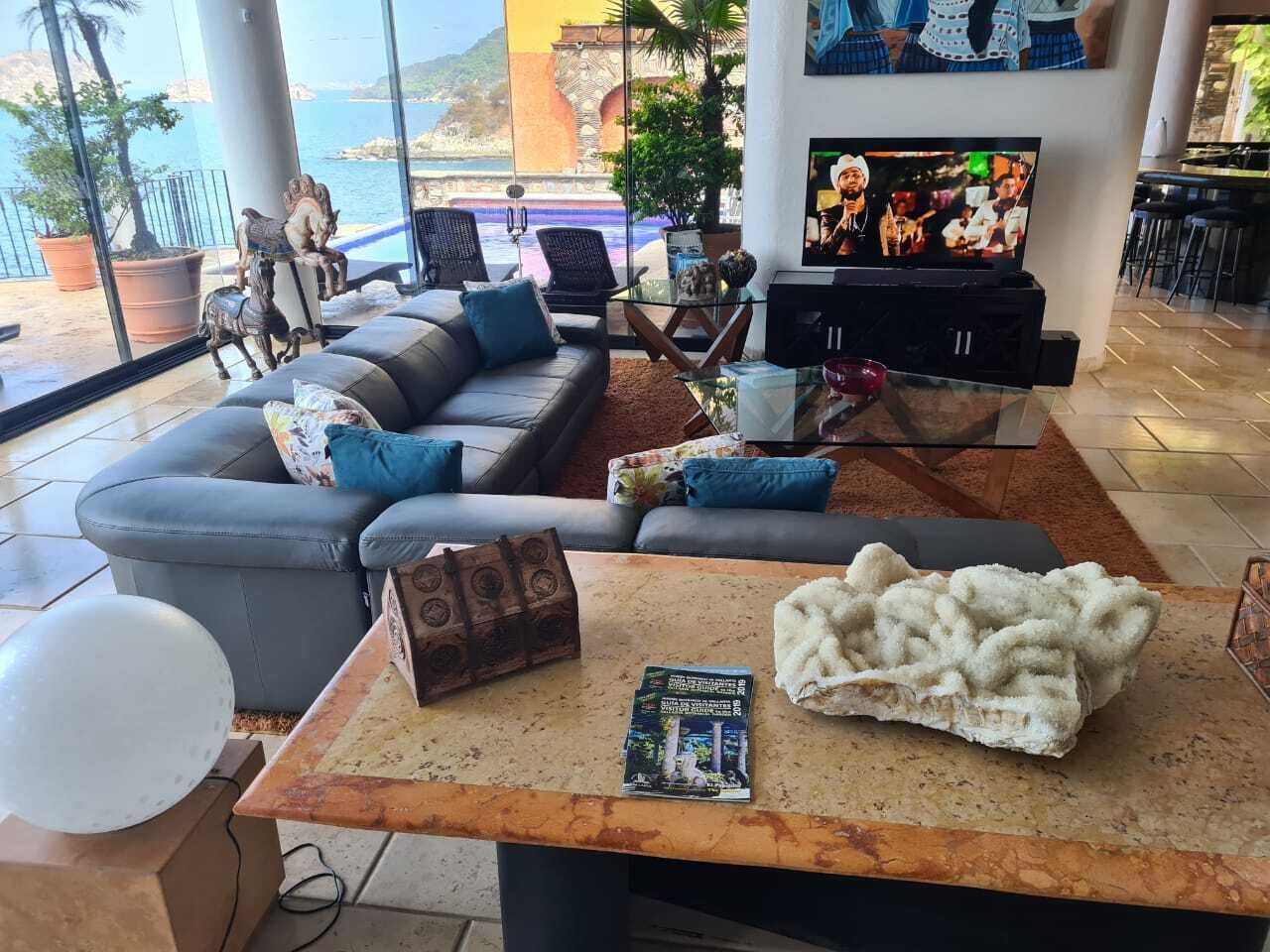 Una sala moderna con un sofá, una mesita de centro y una televisión.