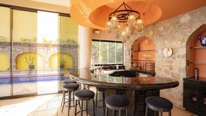 Una cocina moderna con una pared de piedra, un ventanal grande y una zona de bar con taburetes.